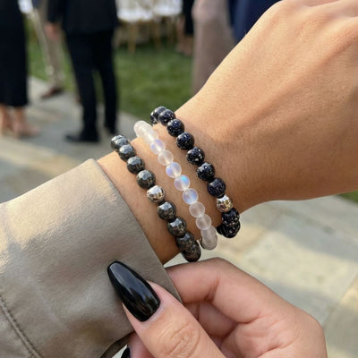 NOGU Made to Pair Chromata MoodSphere bracelet stack with iridescent translucent, dark blue, and faceted metallic bead bracelets.