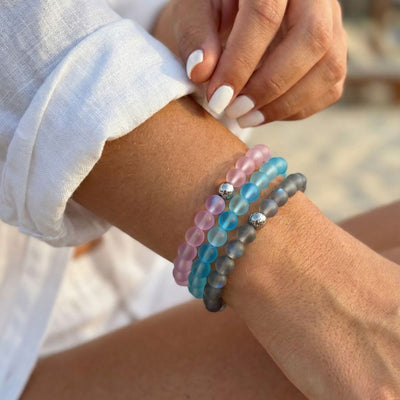 NOGU Made to Pair Aquamarine Mermaid Glass bracelets in frosted pink, aqua blue, and gray beads with silver accents.