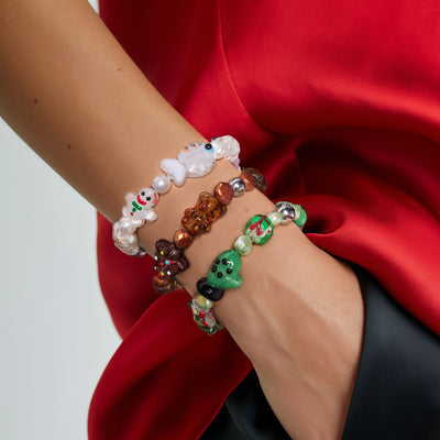 NOGU Christmas Kitsch bracelets with colorful glass holiday charms, pearls and festive gingerbread, snowman and wreath details.