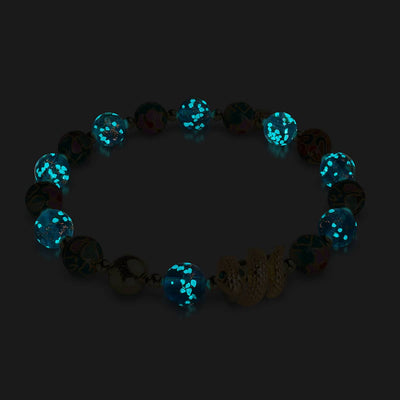 Sea Dragon bracelet glowing with teal firefly glass beads and 18k gold serpent charm on stainless steel by NOGU
