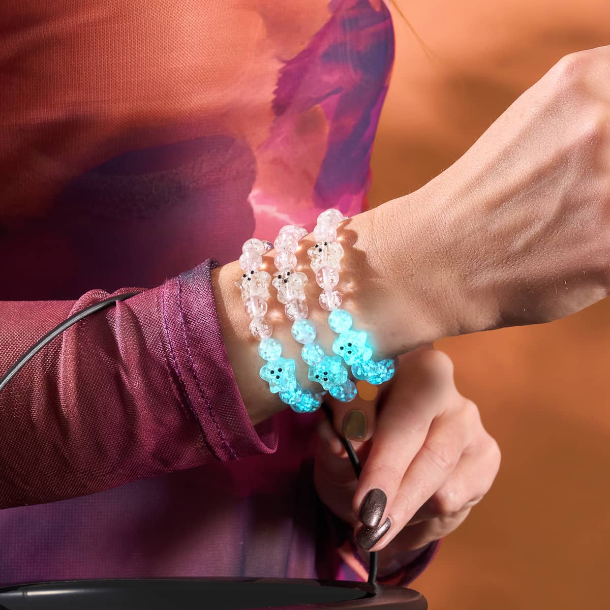 A close-up of the Blushing Spirit Silver Firefly Glass Ghost Bracelet on a wrist.