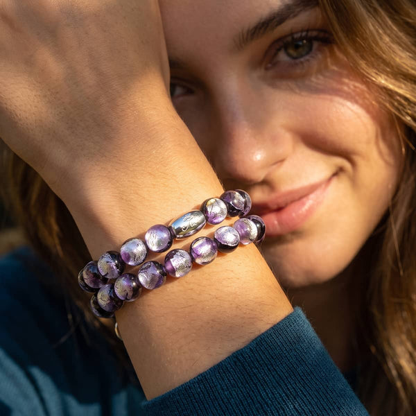 Violet Moon Lunar Glass bracelet with shimmering purple beads and .925 sterling silver accents, shown worn on the wrist.