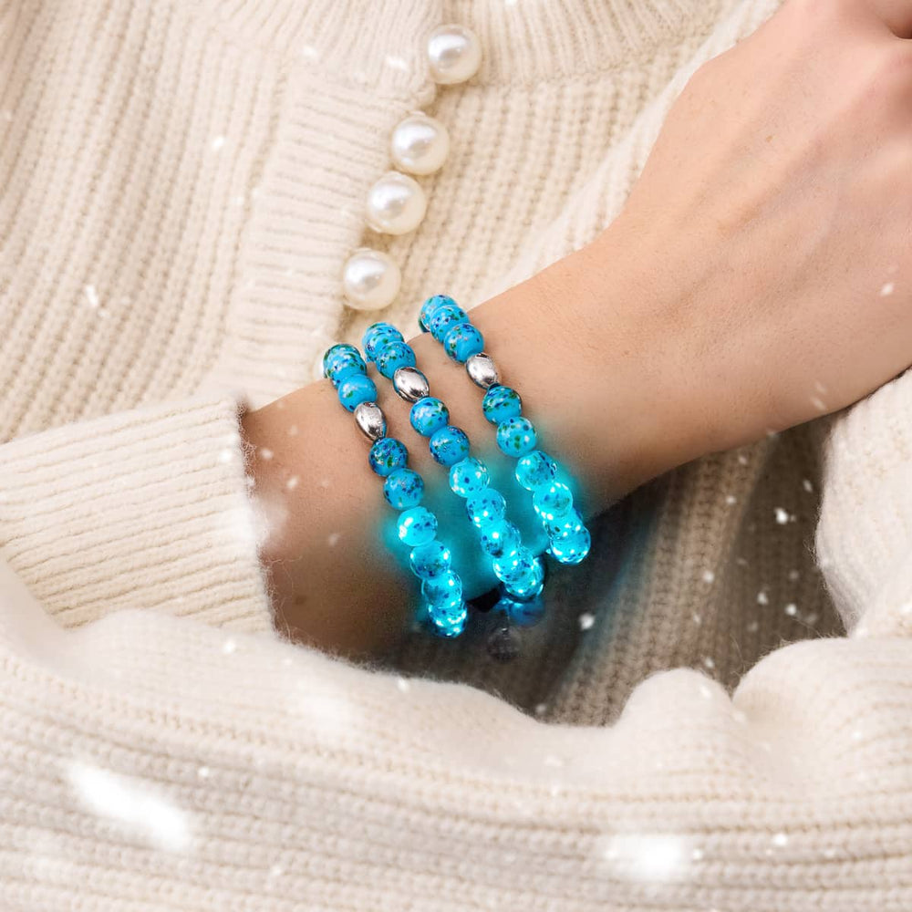 Blue Juniper Firefly Glass Bracelet with glowing blue beads and silver accents worn on wrist by NOGU