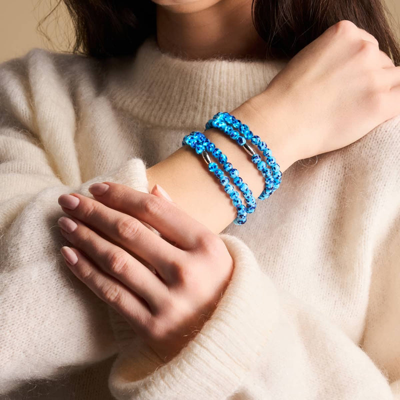 Blue Seaspray Firefly Glass wrap bracelet with 6mm blue beads on sterling silver worn on wrist by NOGU