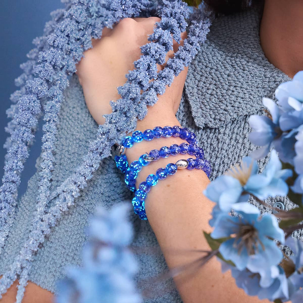 Lapis Lazuli Firefly Glass Bracelet with glowing blue beads and .925 sterling silver clasps worn on wrist by NOGU