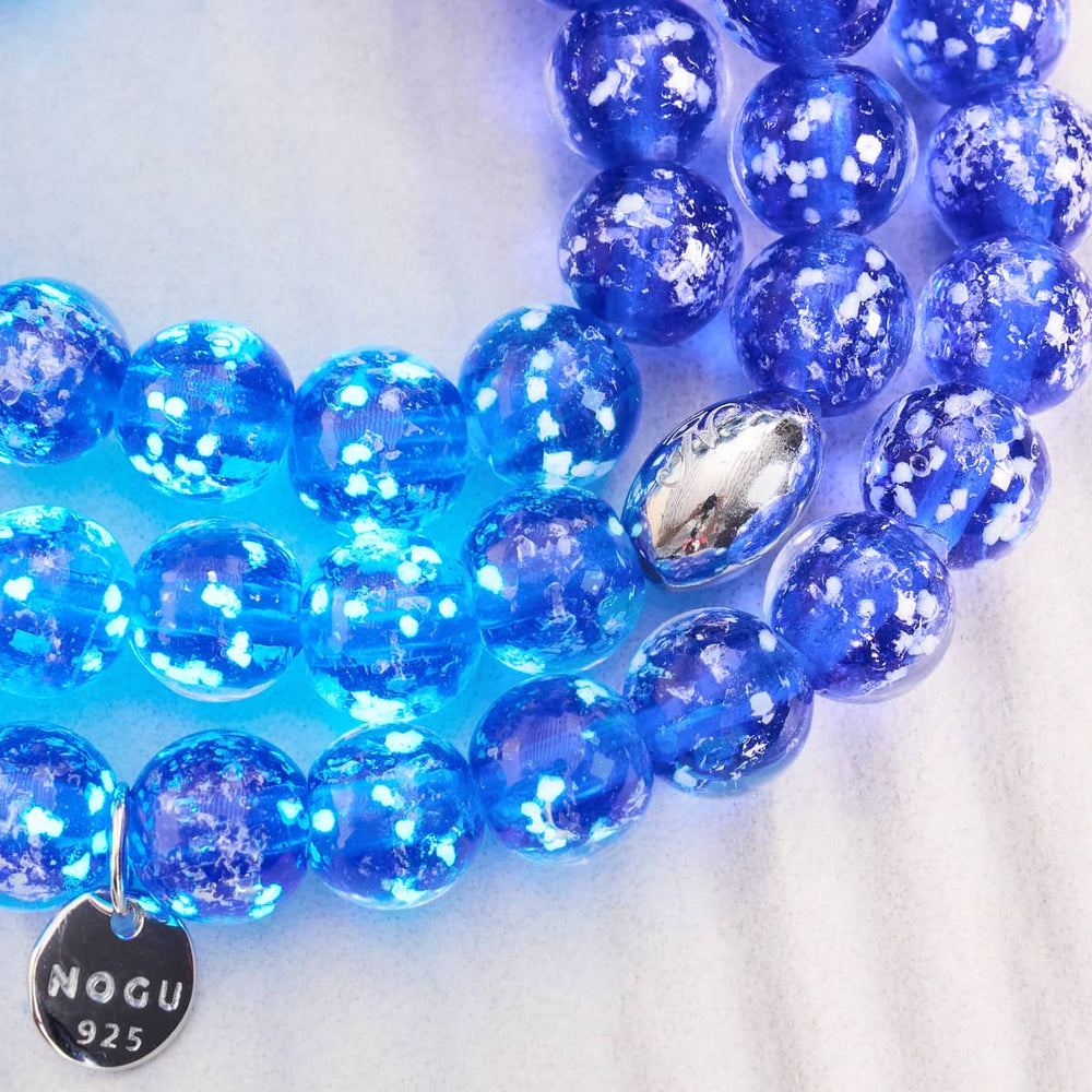 Lapis Lazuli Firefly Glass Bracelet featuring glowing blue beads with .925 sterling silver charm and clasp by NOGU
