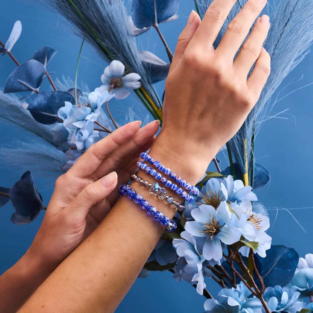 Lapis Lazuli Firefly Glass Bracelet with glowing blue beads and .925 sterling silver clasp worn with other colorful bracelets by NOGU