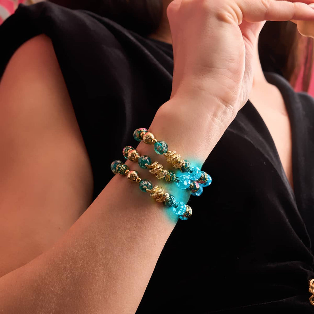 Sea Dragon enamel lotus teal firefly glass serpent bracelets with 18k gold accents worn on wrist by NOGU