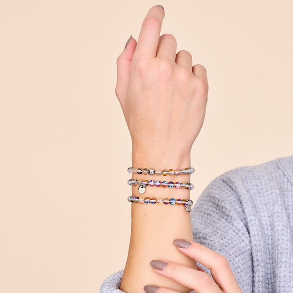 Kaleidoscope silver galaxy glass bead bracelet worn with two similar stretch bracelets featuring multicolor beads by NOGU