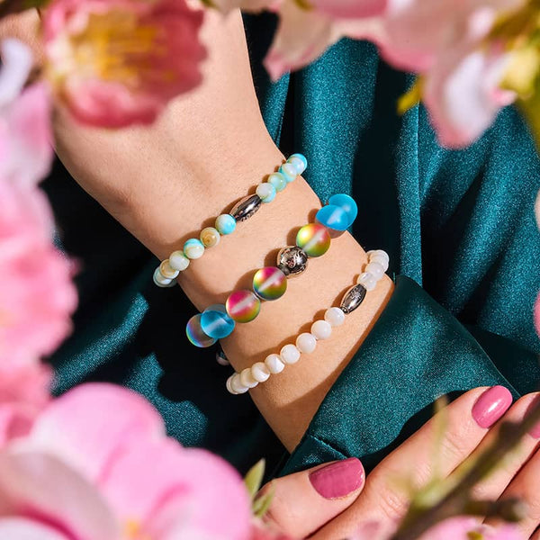 Blue Lemonade Mermaid Glass Statement Bracelet with iridescent 10mm beads and silver charm worn on wrist with other bracelets from NOGU